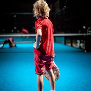 girl in red t-shirt and black pants running on blue floor